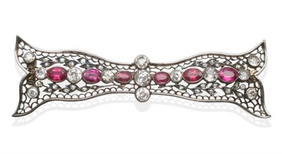 Lot 256 - A Ruby and Diamond Bow Brooch, the pierced bow set throughout with old cut diamonds and oval...