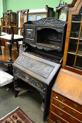 Lot 1311 - Victorian ebonised and carved oak bureau, bearing retail label Godfrey Giles & Co London