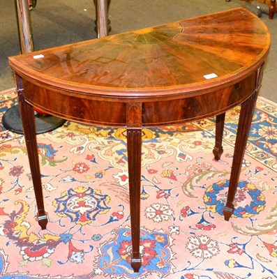 Lot 1338 - A George III style mahogany fold-over card table on square fluted legs