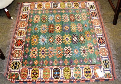 Lot 1364 - Afghan rug of Caucasian design, the apple green field with four rows of latch hook guls enclosed by