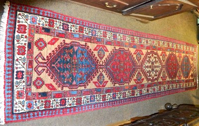 Lot 1422 - Narrow Sarab runner, North West Persia, the camel field with five medallions enclosed by narrow...