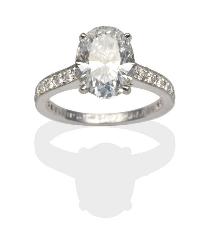 Lot 299 - A Diamond Solitaire Ring, by Cartier, an oval brilliant cut diamond in a white claw setting, to...