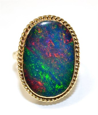Lot 157 - A 9 carat gold boulder opal ring, an oval cabochon opal in a rubbed over setting within a rope...