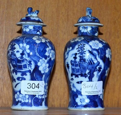 Lot 304 - A pair of Chinese porcelain blue and white prunus pattern vases and covers