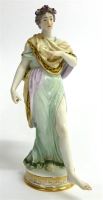Lot 61 - A Meissen Porcelain Figure of a Classical Maiden, 20th century, wearing long robes, flowers in...