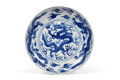 Lot 91 - A Chinese Porcelain Saucer Dish, painted in underglaze blue with dragons chasing the flaming pearl