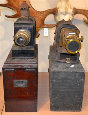 Lot 208 - Two Tinplate and Brass Magic Lanterns, with lenses and wooden carry cases, one lacks chimney