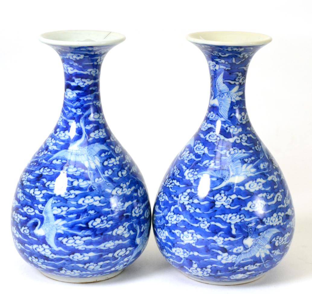 Lot 43 - A Pair of Chinese Porcelain Bottle Vases, 19th century, painted in underglaze blue with cranes...