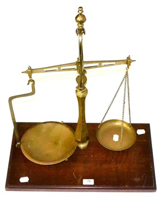 Lot 76 - Brass Pan Scales with two pans one supported by chains the other with a brass arm, on wooden...