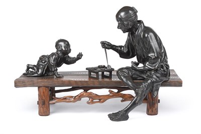 Lot 85 - A Japanese Bronze Table Group, Meiji period, as a seated man holding a rice bowl reaching out...