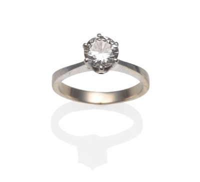 Lot 184 - ~ A Diamond Solitaire Ring, the round brilliant cut diamond in a white six claw setting on a...