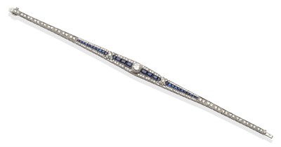 Lot 198 - ~ A Sapphire and Diamond Tapered Bracelet, a round brilliant cut diamond within calibré cut...