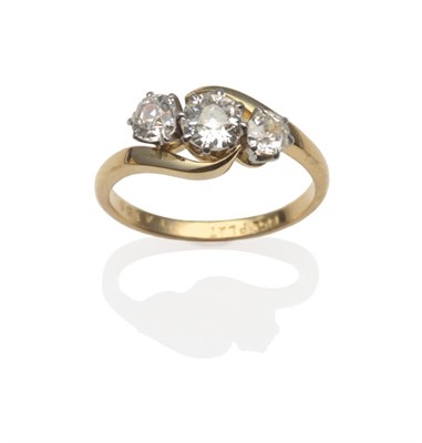 Lot 206 - A Diamond Three Stone Twist Ring, the graduated old cut diamonds in white claw settings on a yellow