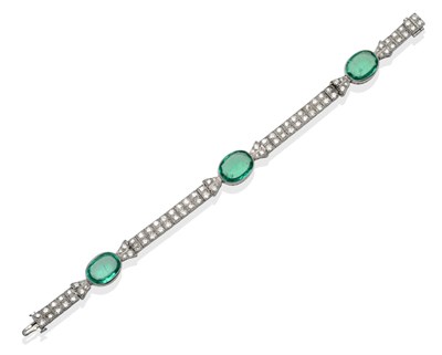 Lot 220 - ~ An Emerald and Diamond Bracelet, three oval cut emeralds, connected by diamond set...