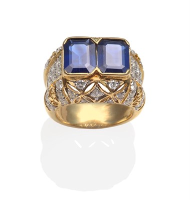 Lot 227 - ~ A Sapphire and Diamond Ring, two emerald cut sapphires in yellow broad claws, with round...