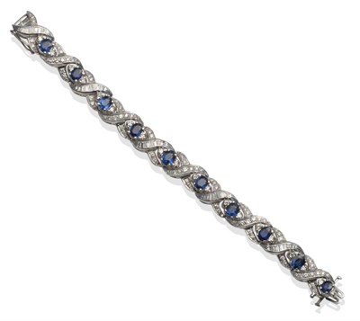 Lot 229 - ~ A Sapphire and Diamond Crossover Bracelet, oval cut sapphires set with round brilliant cut...