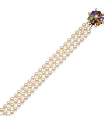 Lot 239 - A Cultured Pearl Necklace, three rows of cultured pearls, knotted to a multi-gemstone clasp,...