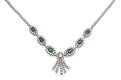 Lot 245 - ~ An Emerald and Diamond Necklace, of six graduated clusters each with an oval cut emerald...