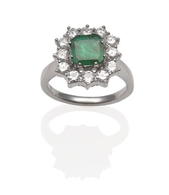 Lot 249 - ~ An Emerald and Diamond Ring, the square emerald-cut emerald within a border of round...