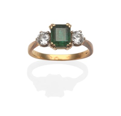 Lot 251 - An 18 Carat Gold Emerald and Diamond Three Stone Ring, the emerald-cut emerald between two...