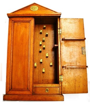 Lot 1047 - A Wall Mounted Oak Army and Navy Tool Cabinet, with makers brass plaque to pediment, hinged...