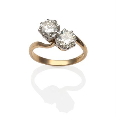 Lot 258 - A Diamond Two Stone Twist Ring, the round brilliant cut diamonds in white claw settings on a yellow