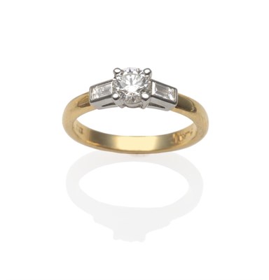 Lot 264 - An 18 Carat Gold Diamond Ring, a round brilliant cut diamond with a baguette cut diamond on...