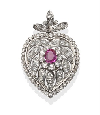 Lot 284 - ~ A Ruby and Diamond Heart Shaped Pendant, the oval cut ruby within a pierced heart shaped...