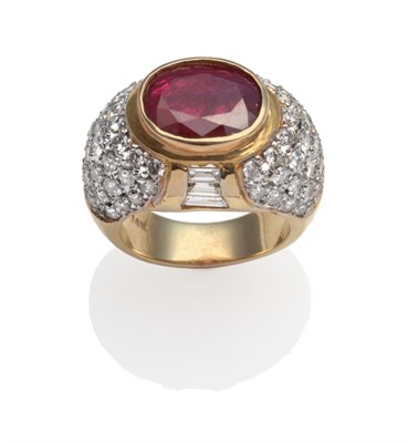 Lot 299 - ~ A Ruby and Diamond Ring, the oval mixed cut ruby in a yellow collet setting, with graduated...