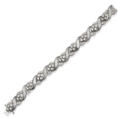 Lot 314 - ~ A Diamond Bracelet, of quatrefoil clusters of round brilliant cut diamonds within swirl links...