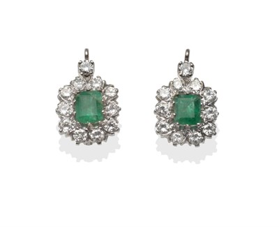 Lot 324 - ~ A Pair of Emerald and Diamond Cluster Earrings, emerald-cut emeralds within a border of round...