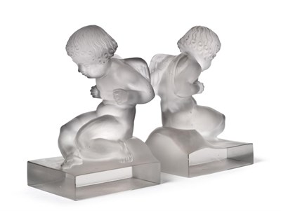 Lot 483 - A Pair of René Lalique Amour Clear and Frosted Glass Bookends, each modelled as seated winged...