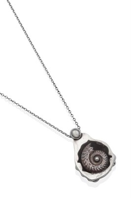 Lot 2027 - An Ammonite Pendant, on Chain, a cast metal ammonite within a 'geode' frame, measures 5cm by...
