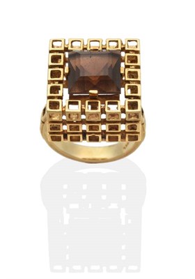 Lot 2035 - A 1970s Smokey Quartz Ring, a square cut smoky quartz in a claw setting, to a pierced cube...