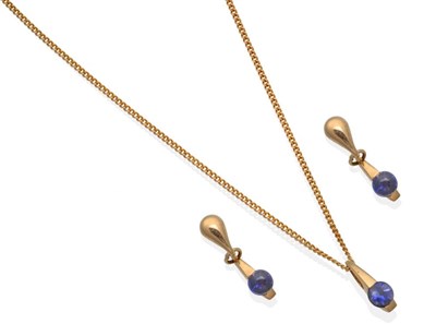 Lot 2070 - A 9 Carat Gold Iolite Pendant and Earring Suite, a round cabochon iolite tension set to a...