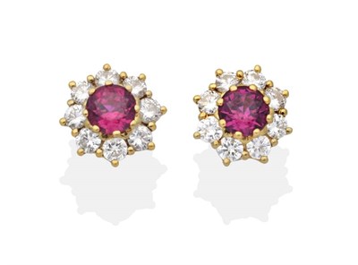 Lot 2084 - A Pair of 18 Carat Gold Ruby and Diamond Cluster Earrings, a round cut ruby within a border of...