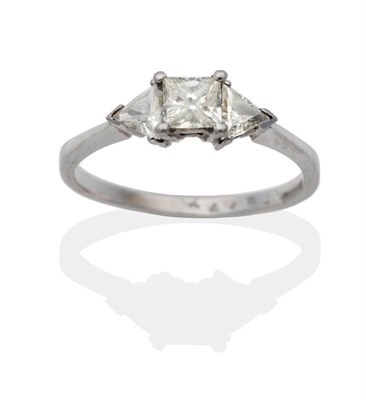 Lot 2111 - An 18 Carat White Gold Diamond Three Stone Ring, a princess cut diamond spaced by trilliant cut...
