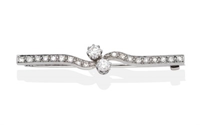 Lot 2133 - A Diamond Bar Brooch, two round brilliant cut diamonds in claw settings, to a bypass scroll bar set