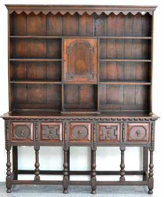 Lot 1053 - An Oak Dresser and Rack, the bold cornice above a wavy shaped apron with fixed shelves above a...