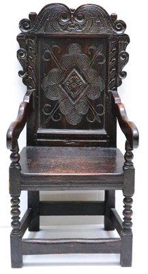 Lot 1059 - A Carved Oak Wainscot Armchair, the lozenge carved back support above a boarded seat raised on...