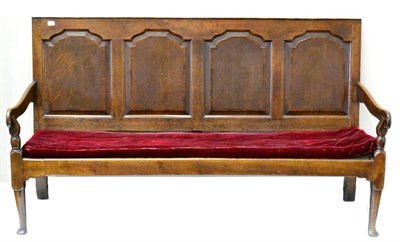 Lot 1066 - A Late George III Joined Oak Settle, circa 1800, the back support with four fielded panels...