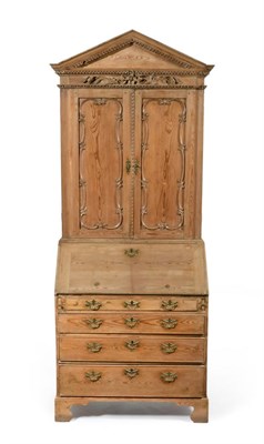 Lot 1081 - A George III Pine Bureau Bookcase, late 18th century, the architectural pediment above a flower and