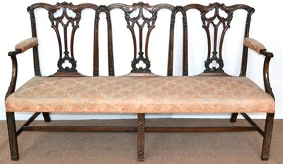 Lot 1176 - A Carved Mahogany Chippendale Style Three-Seater Sofa, upholstered in pink floral silk, the...