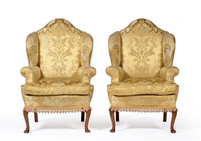 Lot 1179 - A Pair of Early 20th Century Wingback Armchairs, upholstered in yellow silk brocade, with...