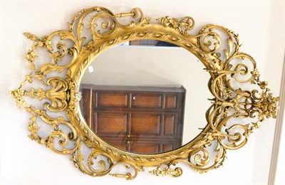 Lot 1201 - A Victorian Gilt and Gesso Oval Wall Mirror, mid 19th century, richly decorated with C scrolls...