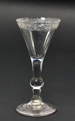 Lot 9 - A Wine Glass, circa 1750, the conical bowl engraved with a band of trophies and swags on a ball...
