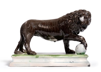 Lot 33 - A Ralph Wood Type Pearlware Figure of a Lion, circa 1780, the standing beast picked out in blue and
