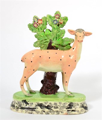 Lot 61 - A Staffordshire Pottery Figure of a Doe, early 19th century, the standing beast with spotted...