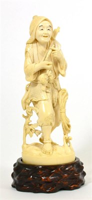 Lot 143 - A Japanese Ivory Okimono, Meiji period, as a man in traditional costume carrying a matchlock...