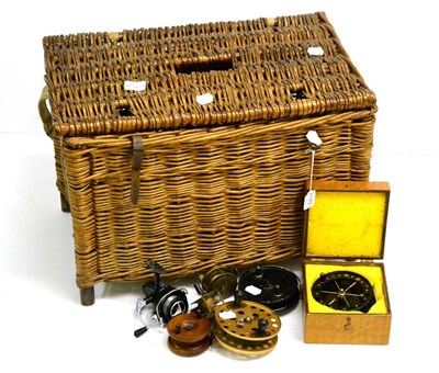 Lot 2149 - A Wicker Fishing Basket Containing Seven Reels, comprising a boxed Aerial type reel, two other...